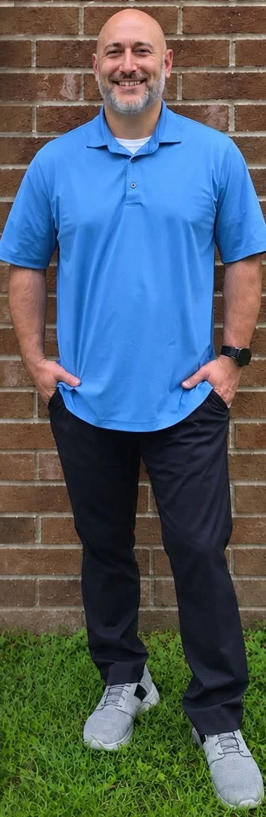 Anthony Smith, owner of Revived Exteriors, standing in front of a brick wall