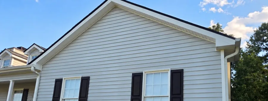 Clean gray vinyl siding on the side of a house after washing